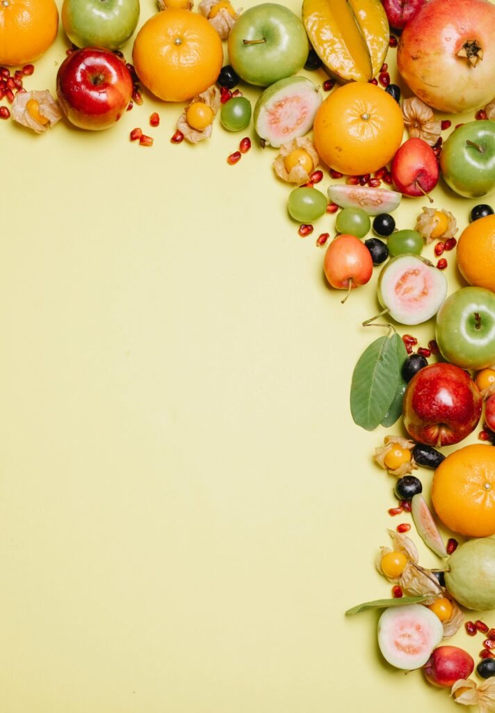 Fresh and colorful assortment of tropical and exotic fruits arranged on a bright yellow background.